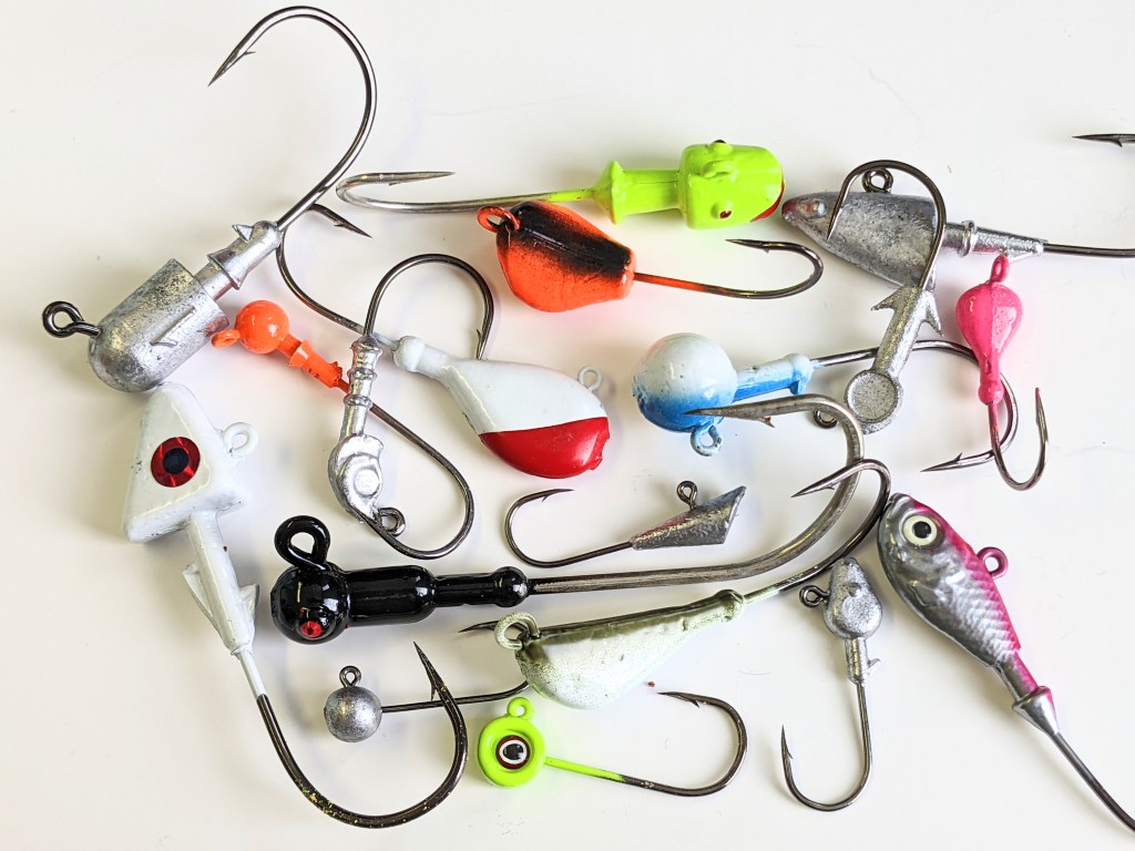 Colorful bucktail Jig heads lure hand tie deer hair and White Shad Jig Head fishing  jig hooks isolated on black Stock Photo